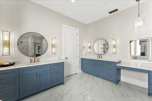 Full bath with marble finish floor, two vanities, a sink, and visible vents
