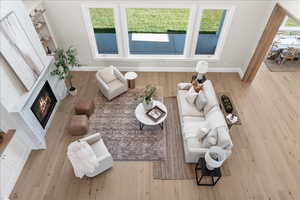 Living room with baseboards, a glass covered fireplace, and wood finished floors