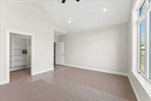 Unfurnished bedroom with carpet flooring, recessed lighting, a walk in closet, and multiple windows
