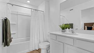 Full bathroom featuring vanity, shower / bath combination with curtain, toilet, visible vents, and wood finished floors