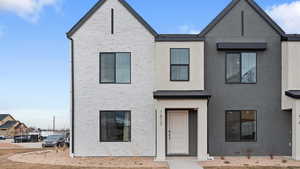 View of property with stucco siding and brick siding