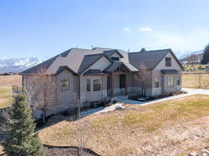 View of front of property with a mountain view, a front lawn, board and batten siding, and roof with shingles