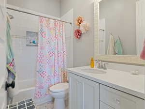 Full bathroom featuring shower / tub combo, vanity, toilet, and tile patterned flooring