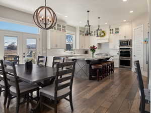 Dining area featuring an inviting chandelier, dark wood-style flooring, french doors, and recessed lighting