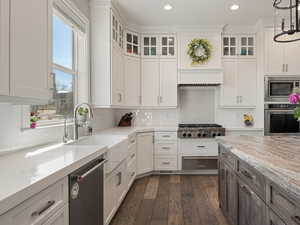 Kitchen with white cabinets, a wealth of natural light, stainless steel appliances, and dark wood finished floors