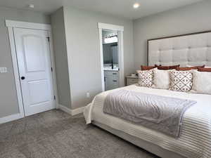 Carpeted bedroom featuring connected bathroom, recessed lighting, and baseboards