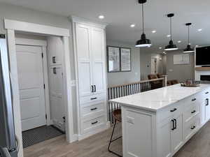 Kitchen with recessed lighting, light wood finished floors, and white cabinets