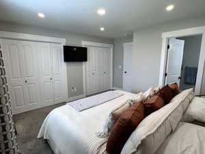 Carpeted bedroom with two closets and recessed lighting