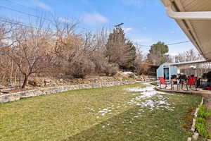 View of yard with a storage unit, fence, an outbuilding, and a patio area