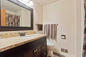 Full bath featuring visible vents, toilet, a shower with curtain, and vanity