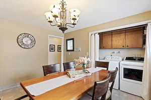 Dining space with chandelier, washer and dryer area