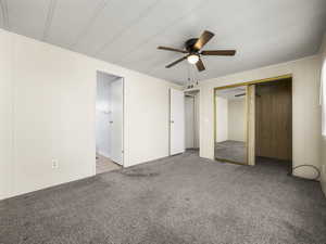 Unfurnished bedroom featuring a closet, carpet flooring, and ceiling fan