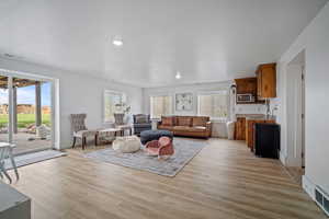 Living area featuring recessed lighting, visible vents, and light wood-style flooring