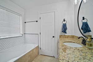 Full bathroom featuring a bath, tile patterned flooring, and vanity