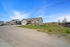 View of front of property featuring fence, a garage, a residential view, a front lawn, and concrete driveway