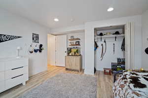 Bedroom featuring baseboards, recessed lighting, wood finished floors, and a closet