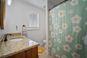 Full bath with visible vents, a shower with shower curtain, toilet, vanity, and tile patterned flooring