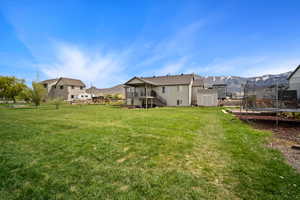 View of yard featuring a trampoline, an outbuilding, a shed, stairs, and a mountain view