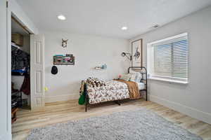 Bedroom with recessed lighting, visible vents, wood finished floors, and baseboards