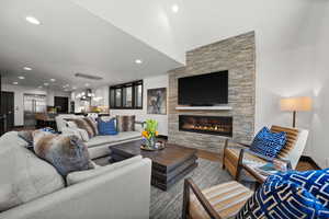 Living area with a fireplace, wood finished floors, and recessed lighting