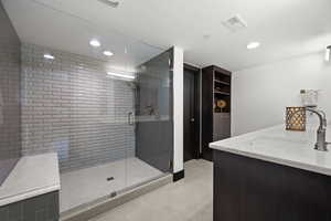 Bathroom featuring a stall shower, vanity, tile patterned flooring, visible vents, and recessed lighting