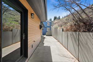 View of side of property with fence and a patio