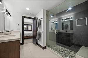 Bathroom with a sink, a stall shower, ensuite bathroom, baseboards, and visible vents