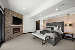 Bedroom featuring light carpet, a large fireplace, baseboards, visible vents, and recessed lighting