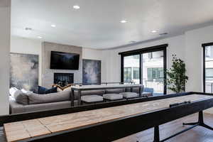 Living area with visible vents, recessed lighting, wood finished floors, and a large fireplace