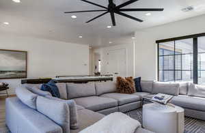 Living room with wood finished floors, visible vents, ceiling fan, and recessed lighting