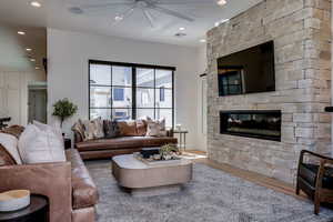 Living area featuring recessed lighting, wood finished floors, ceiling fan, a fireplace, and visible vents