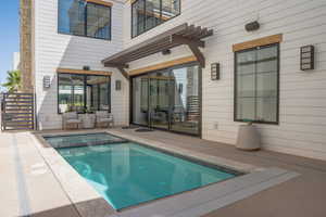 View of swimming pool with a pool with connected hot tub and a patio area