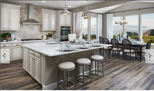 Kitchen featuring wall chimney range hood, a sink, light countertops, gas stovetop, and backsplash