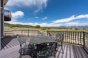 Wooden deck featuring a mountain view and outdoor dining space