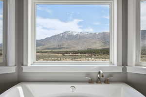 Interior space with a soaking tub and a mountain view