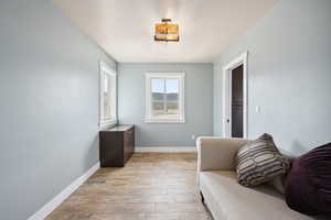 Sitting room with light wood-style floors, visible vents, and baseboards