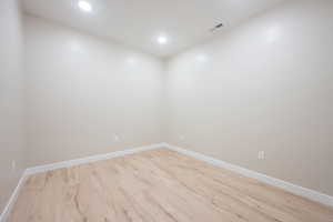 Unfurnished room with light wood finished floors, recessed lighting, visible vents, and baseboards