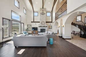 Living area featuring a towering ceiling, stairs, wood finished floors, and baseboards