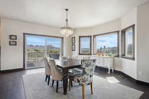 Dining area with baseboards, visible vents, an inviting chandelier, and dark wood finished floors