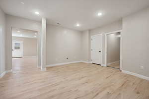 Below grade area with baseboards, visible vents, light wood finished floors, and recessed lighting