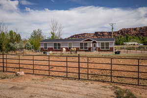 Single story home with board and batten siding, fence, roof with shingles, and a mountain view
