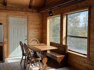 Dining room with wood walls, beamed ceiling, and wood ceiling