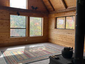 Spare room with wood ceiling, a wealth of natural light, and lofted ceiling with beams