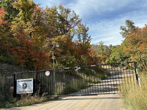 View of gate with a wooded view