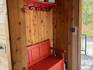 Mudroom featuring wooden walls