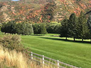 View of home's community with a mountain view, fence, and a yard