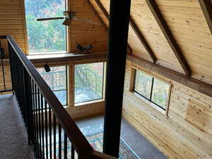Stairs with wood ceiling, wood walls, ceiling fan, carpet flooring, and beam ceiling