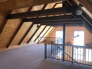 Additional living space with vaulted ceiling with beams, carpet, and wood ceiling