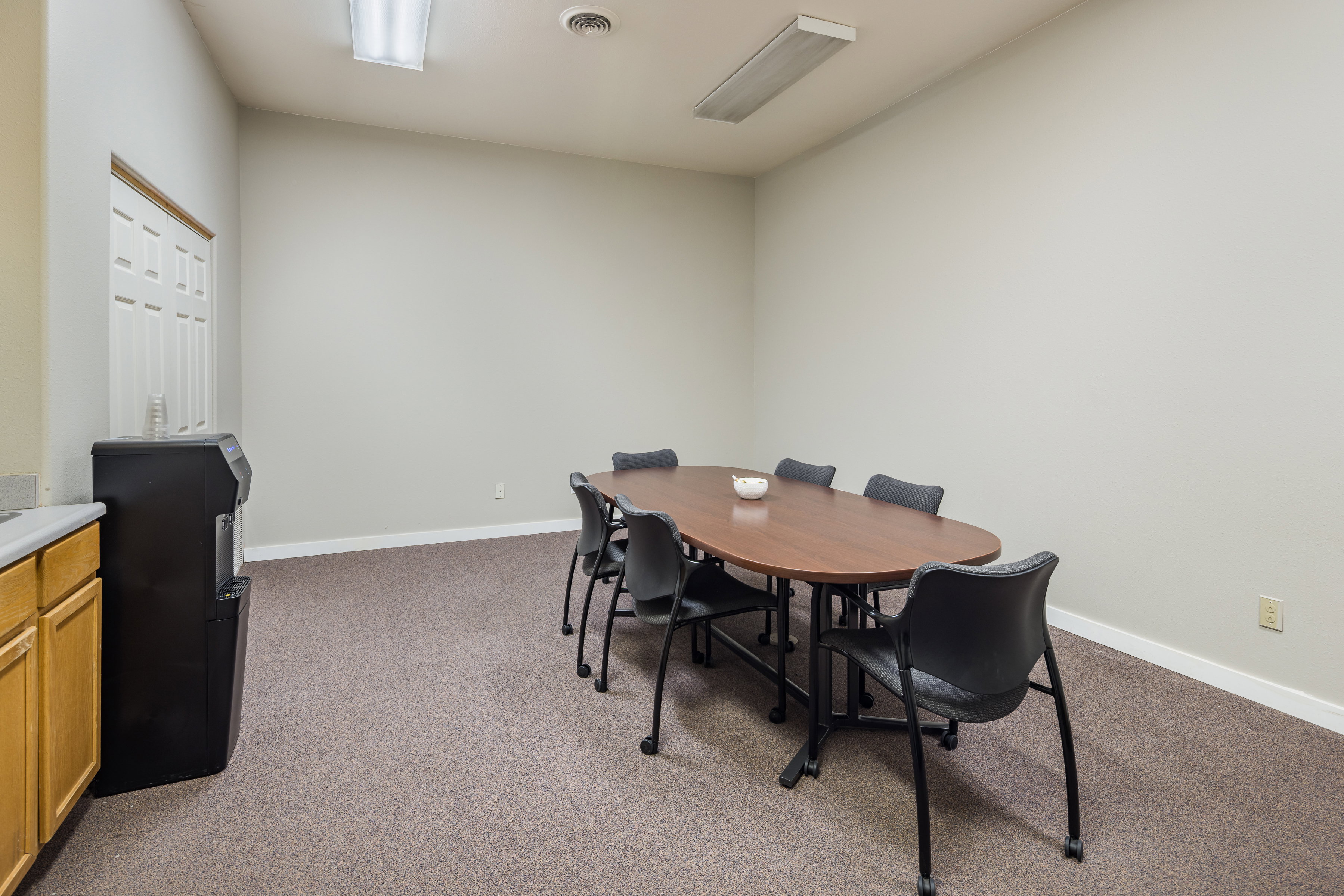 Dining space featuring dark colored carpet, visible vents, and baseboards