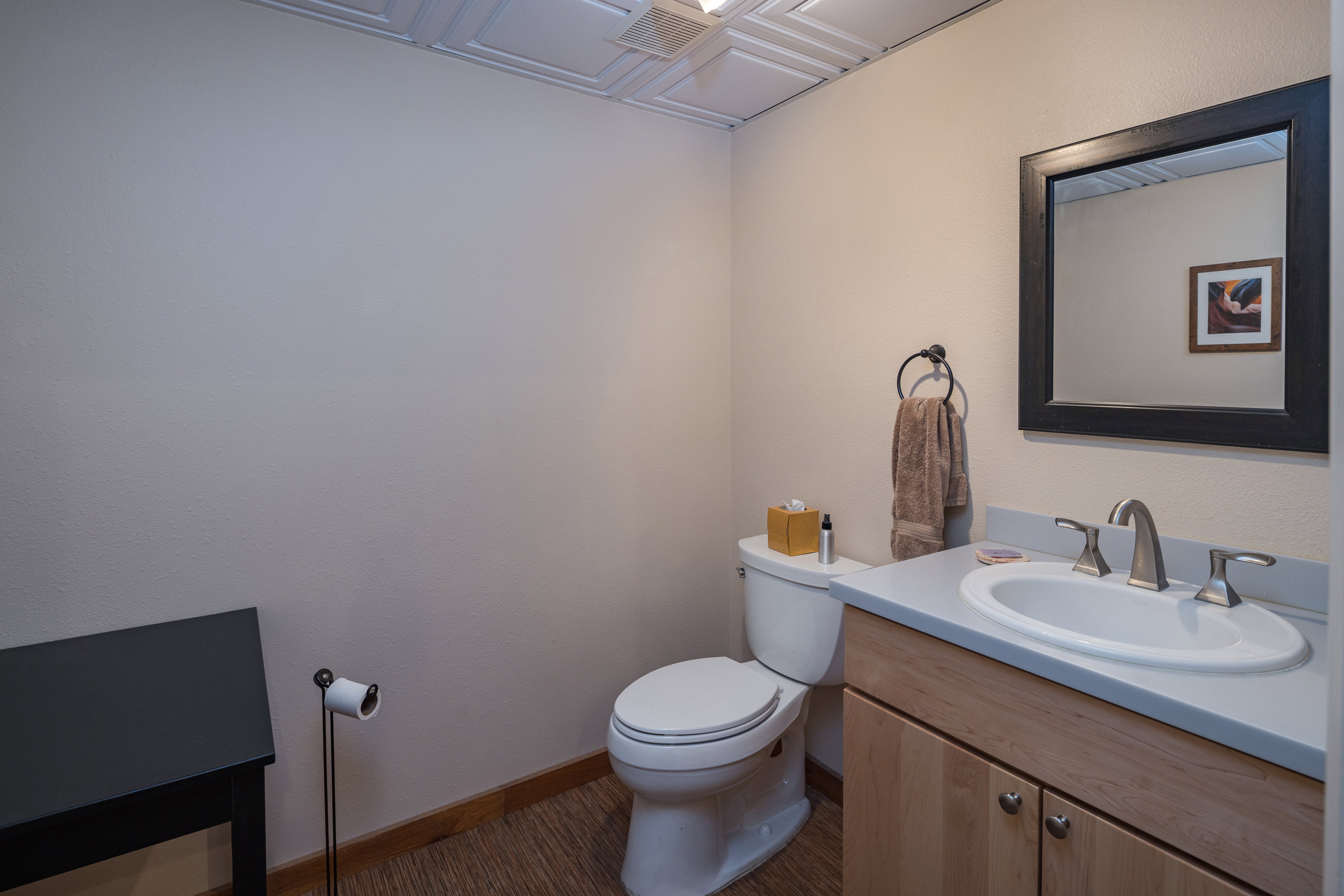 Bathroom featuring baseboards, wood finished floors, toilet, and vanity